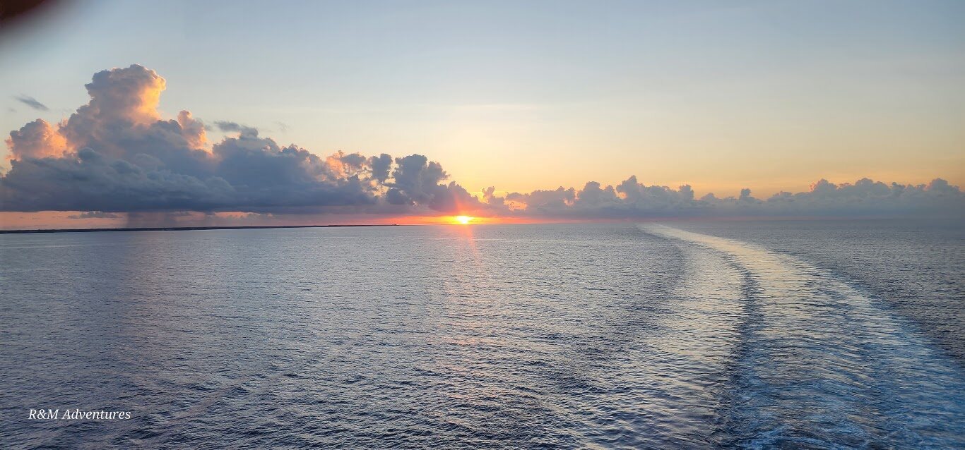 Sunset over the ocean and a cruise ship wake